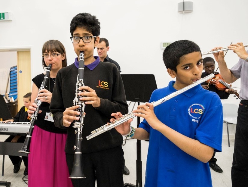 Secondary school pupils playing clarinets and flutes